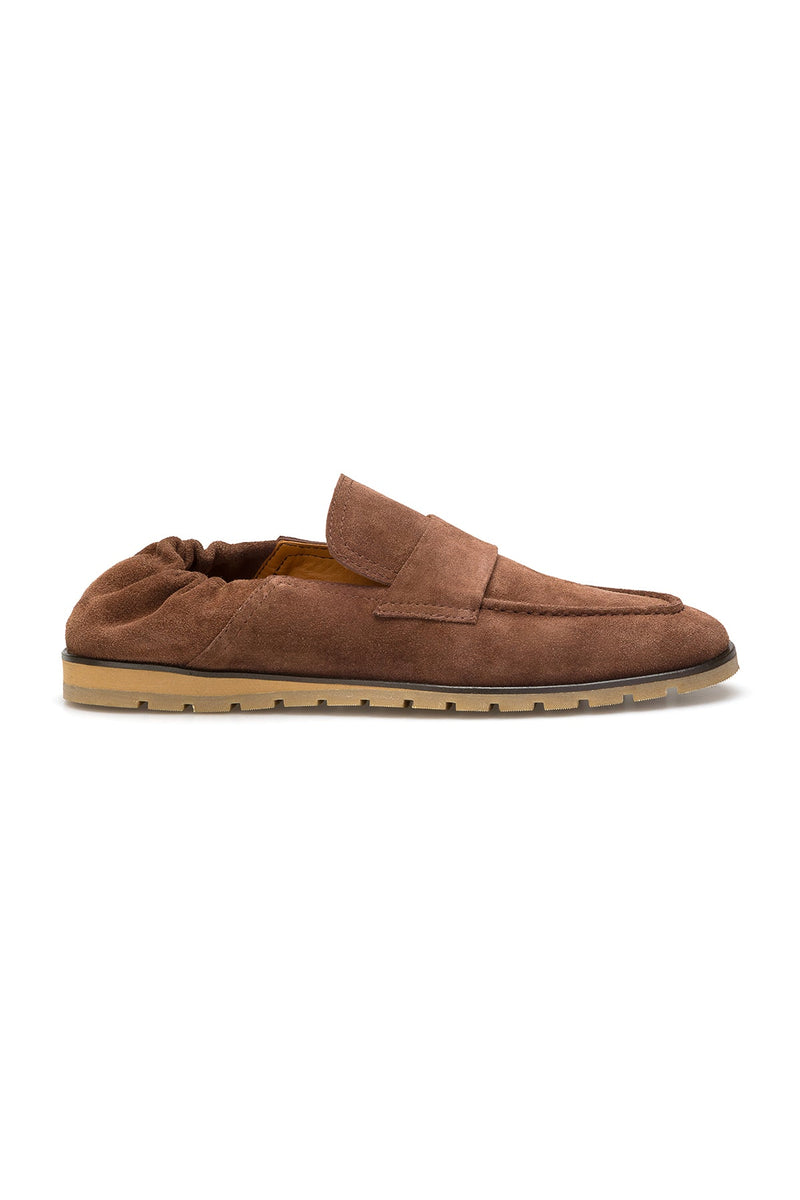 Seitliche Ansicht eines Wildleder-Loafers in Terracotta, zeigt die geschmeidige Sohle und das klassische Schlüpfer-Design