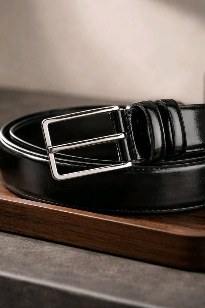 Gros plan de la ceinture noire en cuir verni, surface en cuir brillante en détail