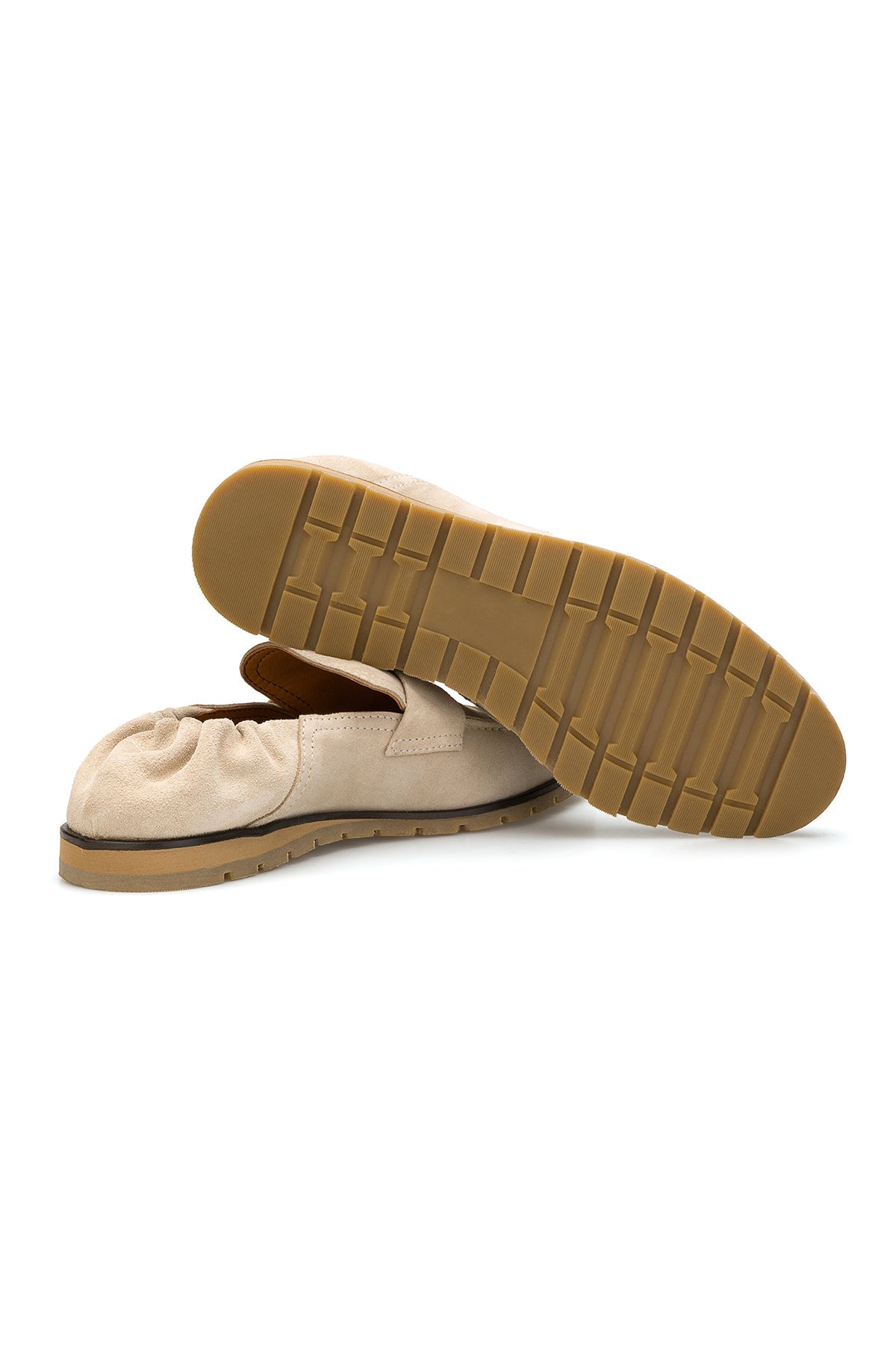 Loafer in beige Wildleder auf einer eleganten Holzbodenfläche, stilvoll präsentiert
