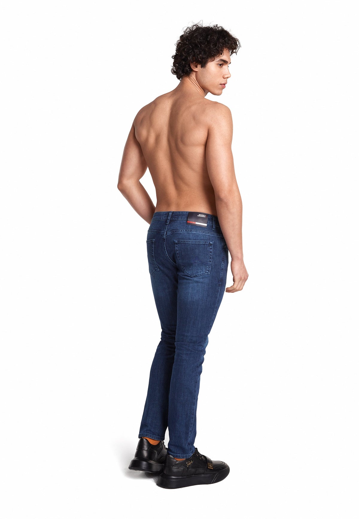 Le modèle porte le jean slim en bleu, mettant en valeur la coupe moderne.