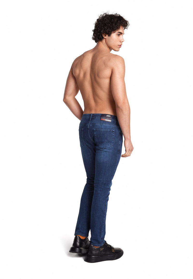 Modell trägt die Slim‑Fit Jeans in Blau, betont die moderne Passform.