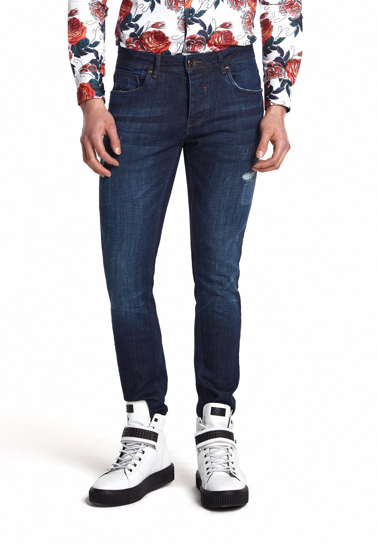 Jean slim bleu marine associé à des baskets classiques pour un look décontracté