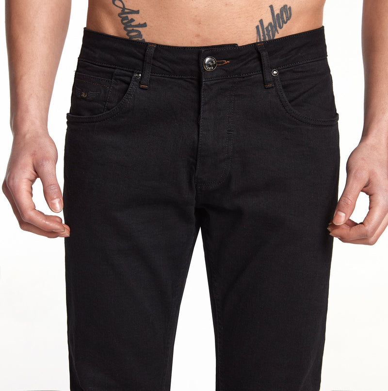 Modell trägt die schwarze Jeans, kombiniert mit klassischen Loafer-Schuhen.
