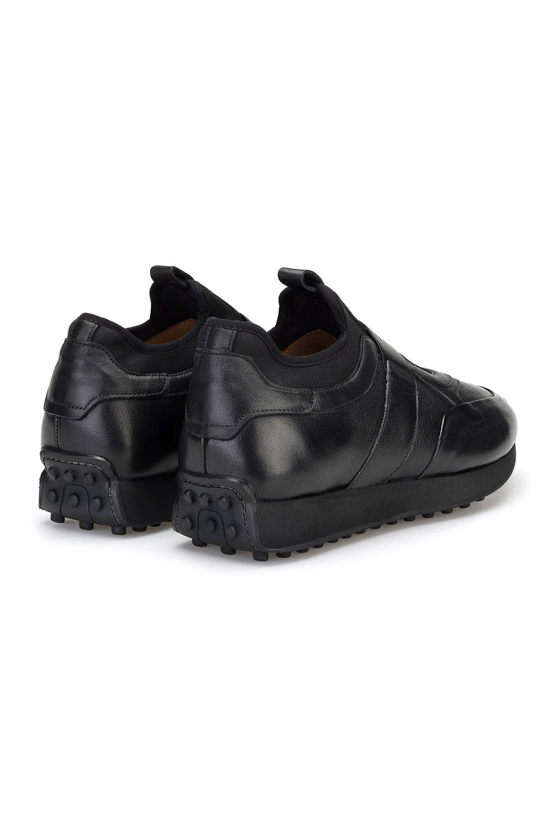 Blick von oben, zeigt die Schlüpfer-Schließe des schwarzen Sneakers.