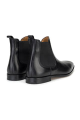 Schwarzer Chelsea-Boot auf einem eleganten Winterweg getragen