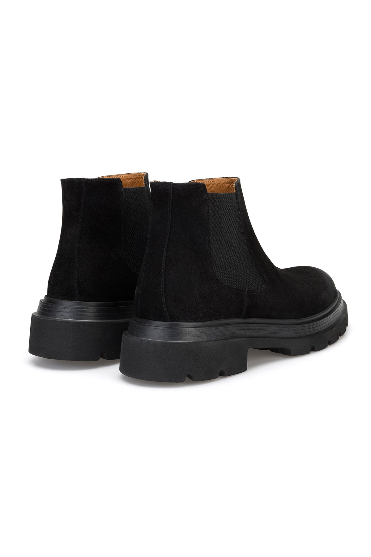 Lederstiefel auf einem schneebedeckten Gehweg – winterliche Stimmung