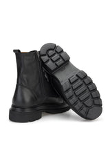 Modell trägt den schwarzen Lederstiefel in urbanem Setting