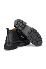 Stiefel in stilvollem Schuhregal, Schwarz und Leder
