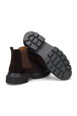 Mann trägt die Wildleder-Stiefel in Braun – stilvoller Winterlook im urbanen Setting.