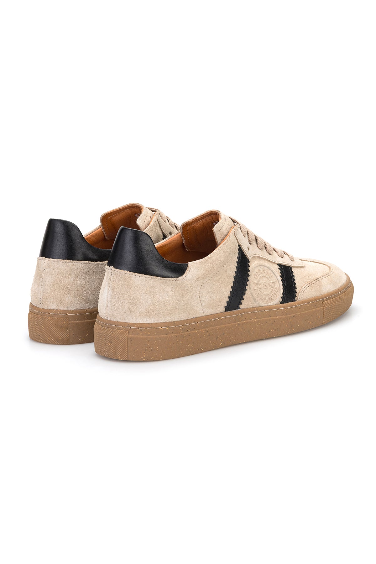Modisches Bild eines Mannes in Jeans, trägt die Beige‑Schwarz Sneakers für urbanen Alltag