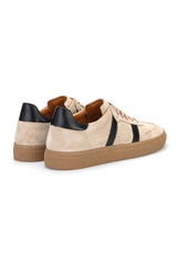 Modisches Bild eines Mannes in Jeans, trägt die Beige‑Schwarz Sneakers für urbanen Alltag