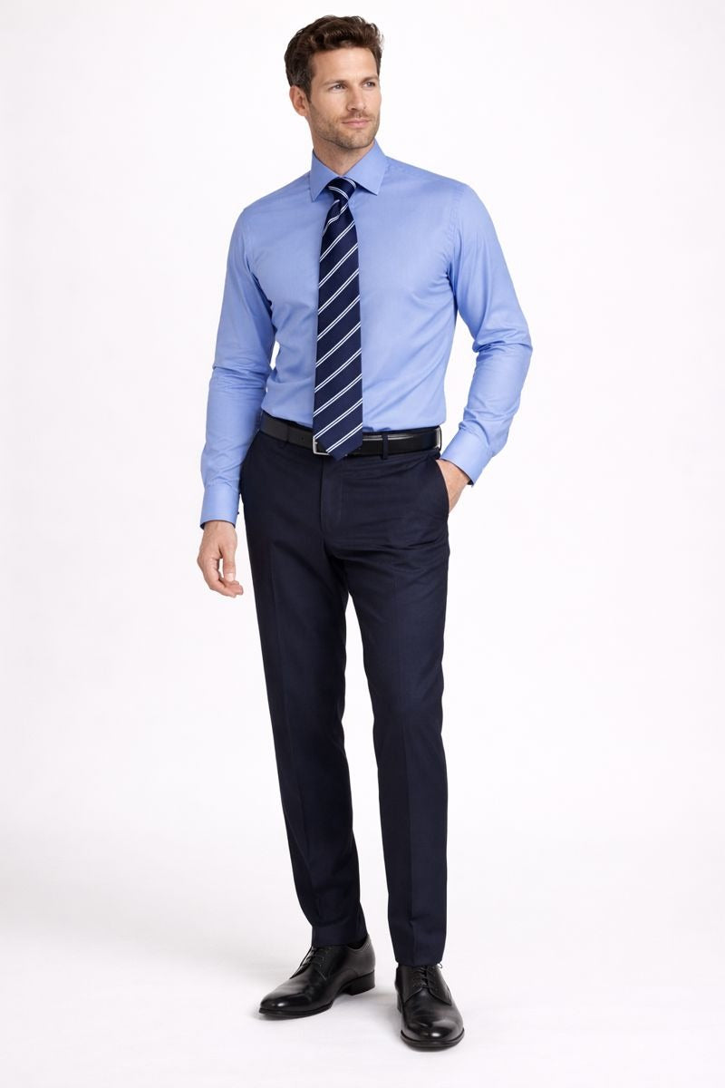 Un homme porte la chemise slim-fit bleue à col long, associée à une veste pour un look business