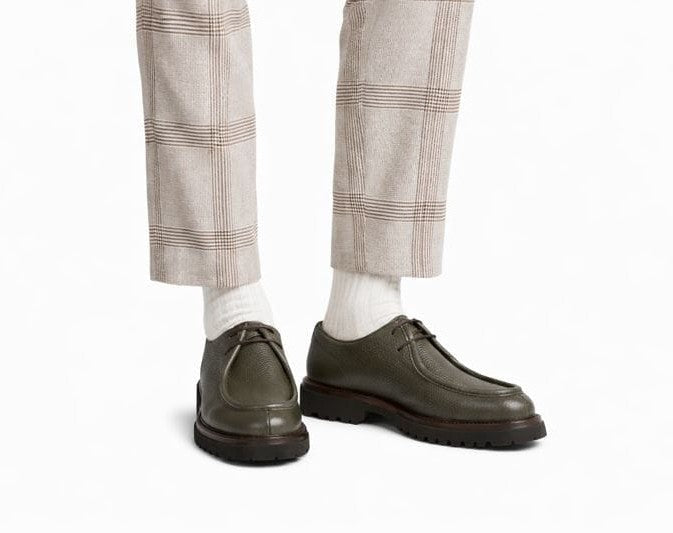 Chaussure sur fond neutre, mettant en valeur la couleur naturelle vert kaki et la texture du cuir.