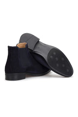 Modebeispiel: dunkelblaue Chelsea-Boots kombiniert mit dunklem Anzug für einen eleganten Look
