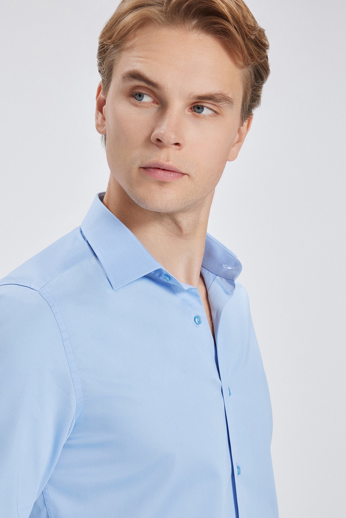 Detailaufnahme der feinen Satinierung des Baumwollstoffs im Slim Fit Business Hemd, hellblau.