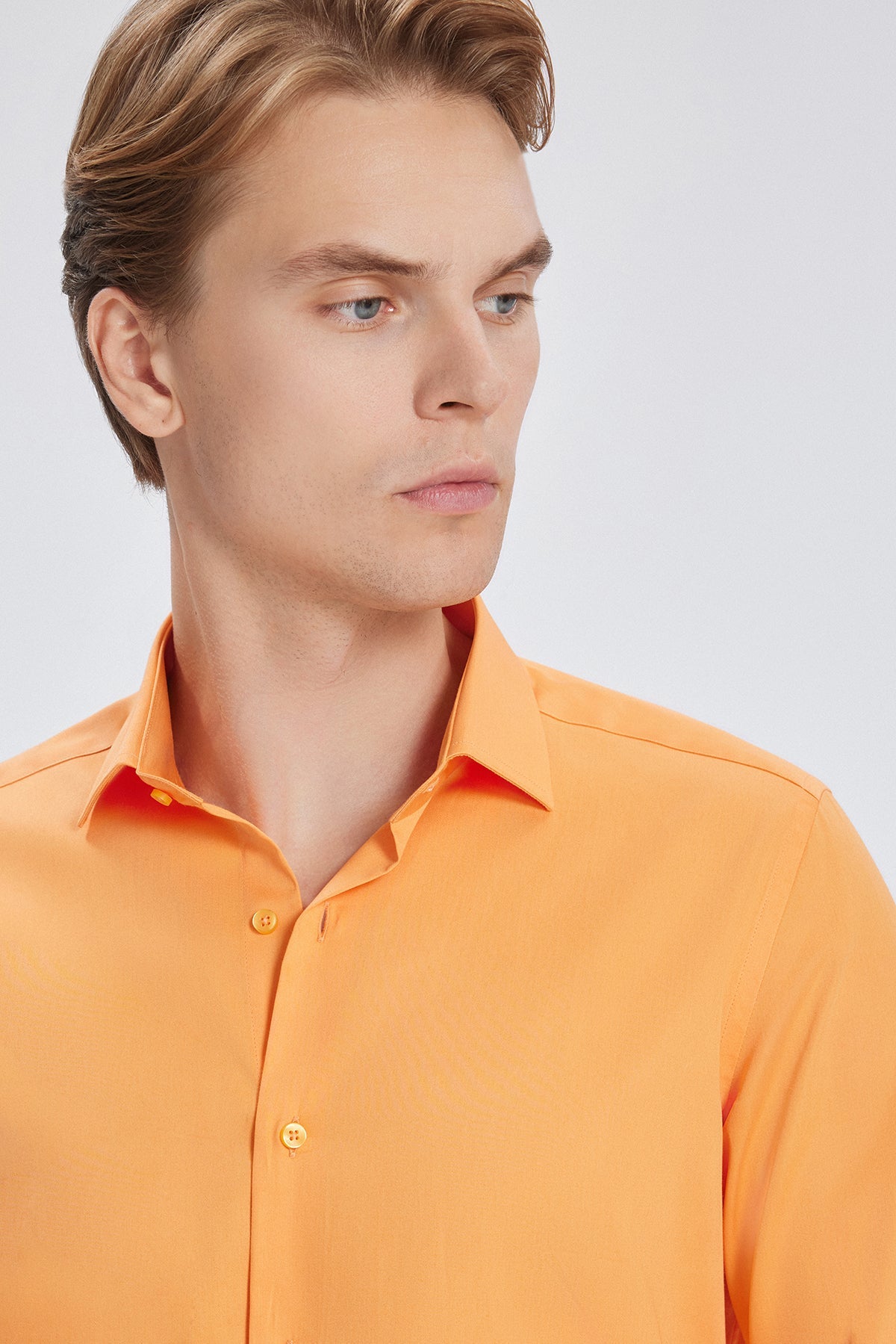 Gros plan sur le coton satiné, texture brillante visible de la chemise.