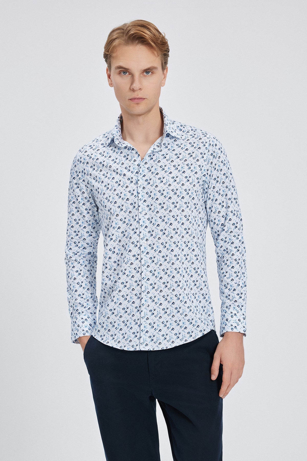 Modell trägt das Slim-Fit Hemd in Weiß-Blau bei Tageslicht