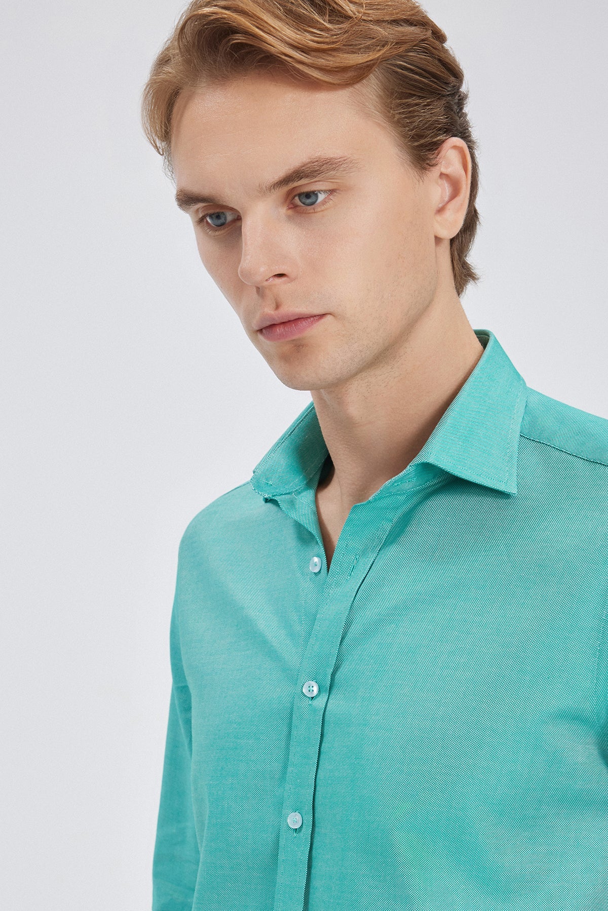 Nahaufnahme der feinen Nähdetails des Slim Fit Hemds in Grün, die den eleganten Look unterstreichen.