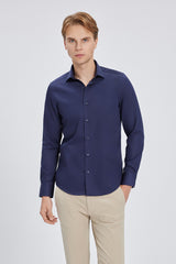 Modell trägt das Navy-Blau Slim Fit Hemd, demonstriert die moderne Silhouette im Büro